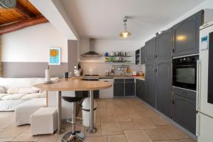 a kitchen with gray cabinets and a wooden table at Le Petit Paradis in Labastide-de-Virac