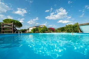 a large swimming pool with a house in the background at Le Petit Paradis in Labastide-de-Virac +7 photos