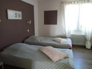 two twin beds in a room with a window at Le Petit Paradis in Labastide-de-Virac