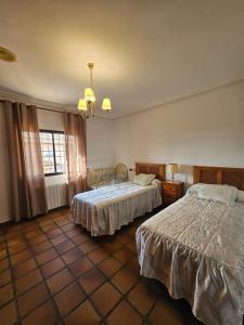 a hotel room with two beds and a window at Casa Rural El Hollejo in Pulgar