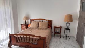 a bedroom with a wooden bed with two night stands and two lamps at Apartment in secure residence in Constantine