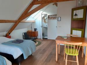 a bedroom with a bed and a desk and a table at Sport B&B De Veluwezoom in Velp