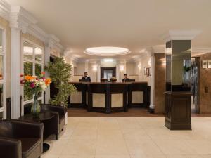 a lobby with two people sitting at a desk at Royal Eagle Hotel in London