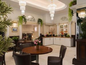 a restaurant with tables and chairs in a room at Royal Eagle Hotel in London