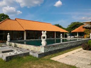 a resort with a swimming pool and a building at Jepara Marina Beach Bungalows in Jepara