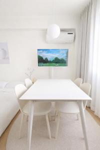 a white dining room with a white table and chairs at 온스테이 송파 On Stay Songpa in Seoul +13 photos