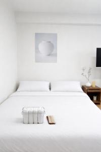 a white bed with a basket on top of it at 온스테이 송파 On Stay Songpa in Seoul