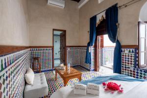 a bedroom with a bed and a couch and a table at Riad Jasmine in Rabat