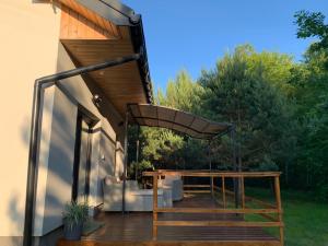 a patio with a wooden table and an umbrella at Domek Wśród Pól z Balia Jacuzzi in Rawa