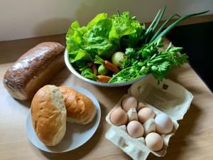 a table with a plate of bread and a salad and eggs at Domek Wśród Pól z Balia Jacuzzi in Rawa +10 photos