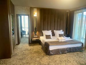 a bedroom with a large bed with white sheets and pillows at Hotel Royal Plovdiv in Plovdiv +86 photos