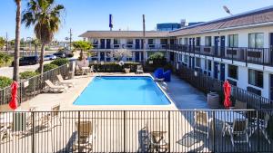 a swimming pool in front of a building at Studio 6 Galveston TX in Galveston