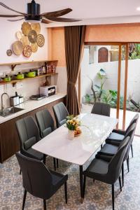 a dining room with a white table and chairs at Linh Lan Homestay in Phan Thiet