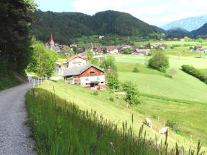 a village on a hill with cows in a field at Hanslmoar Hof in Colli in Pusteria