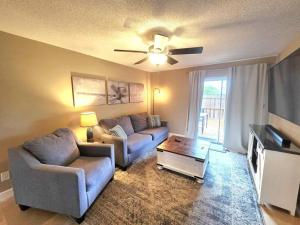 a living room with two couches and a flat screen tv at Nautical Costa Del Mar on Holiday Isle in Destin