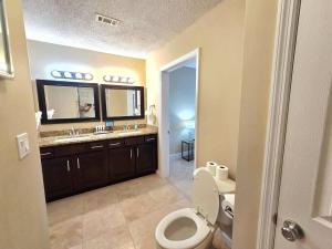 a bathroom with a toilet and a sink and a mirror at Nautical Costa Del Mar on Holiday Isle in Destin +38 photos