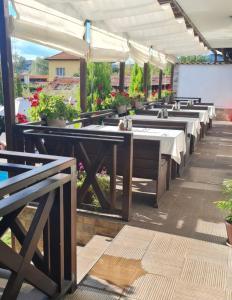 a row of tables with white umbrellas on a patio at Einstein House & Spa in Marchevo