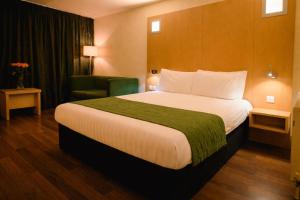 a hotel room with a large bed and a chair at Station House Hotel Letterkenny in Letterkenny