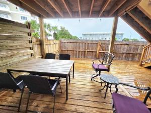 a wooden table and chairs on a wooden deck at Nautical Costa Del Mar on Holiday Isle in Destin
