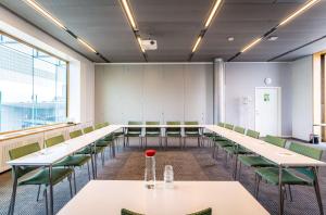 ein Konferenzraum mit weißen Tischen und grünen Stühlen in der Unterkunft Scandic Talk in Stockholm