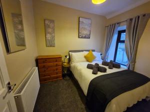 a bedroom with a bed with two teddy bears on it at Kellys Place Derry City Centre in Derry Londonderry