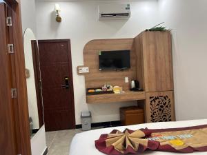 a bedroom with a bed and a tv on the wall at Minh Minh Nam 3 Hotel in Can Tho