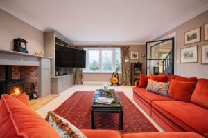 a living room with a red couch and a fireplace at Kyuquot House in Woodbridge