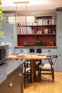 a kitchen with a table and chairs and bookshelves at Kyuquot House in Woodbridge