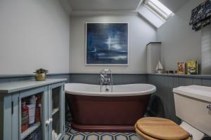 a bathroom with a bath tub and a toilet at Kyuquot House in Woodbridge +41 photos