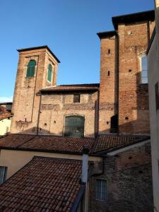 un antiguo edificio de ladrillo con dos torres y un techo en San Leonardo House Bologna, en Bolonia