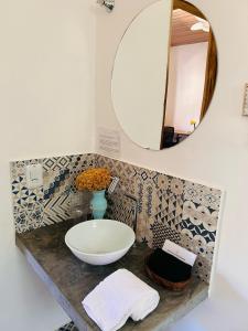 a bathroom with a sink and a mirror at Flor e Luz Chalés in Vale do Capao