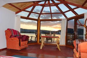 a room with a large window with a table and chairs at TiticacaIntiLodge in Puno
