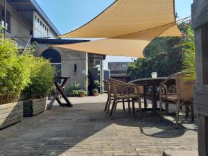 a table and chairs under an umbrella on a patio at Sport B&B De Veluwezoom in Velp