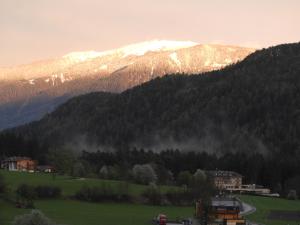 a snow covered mountain with a town in a field at Hanslmoar Hof in Colli in Pusteria