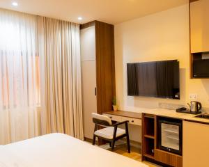a hotel room with a bed and a desk with a television at 7EVEN Suites in Lagos