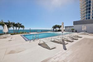 a swimming pool with lounge chairs and umbrellas at MonteCarlo Miami Beach in Miami Beach