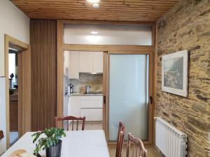a kitchen and dining room with a stone wall at A casa do lajueiro in Arzúa
