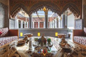 ein Wohnzimmer mit einem Glastisch in einem Gebäude in der Unterkunft Riad Fes Maya suite & spa in Fès