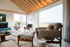 a living room with a couch and a chair at The Barn at Manor Farm in Great Glemham