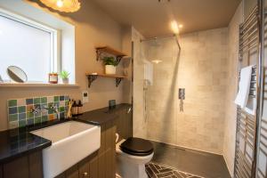 a bathroom with a sink and a toilet and a shower at The Barn at Manor Farm in Great Glemham +41 photos