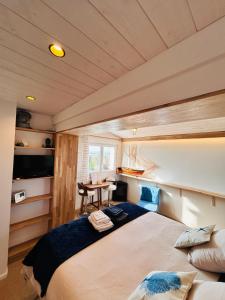 a small room with a bed and a table at "La Cabine" côté mer et côté jardin à la VILLA PLEIN VENT in Barneville-Carteret