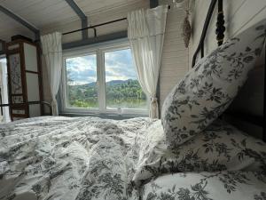 a bedroom with a bed and a large window at La Măgaru Tăvălit in Nucşoara