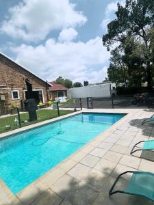 a swimming pool with blue water in a yard at The Morrison in Randburg