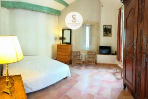 a bedroom with a bed and a dresser and a television at Nicolaï Arles centre in Arles