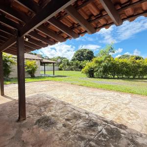an outdoor patio with a wooden pergola at Chacara Italia in Uberaba