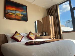 a bedroom with a large white bed with a window at Minh Minh Nam 3 Hotel in Can Tho