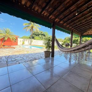a hammock on a patio with a pool at Chacara Italia in Uberaba +18 photos