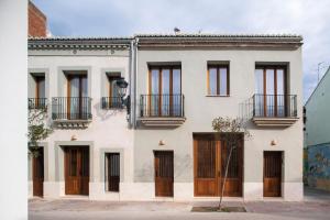 a white house with wooden doors and windows at Mon Suites San Pedro in Valencia