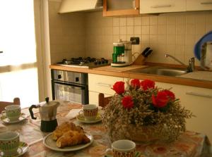 a kitchen with a table with food and flowers on it at Appartamenti Maria Grazia in Dongo