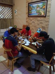 a group of men sitting around a table eating food at Hotel Ejecutivo VIP, La Paz in La Paz